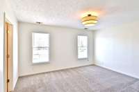 Primary bedroom suite. Lots of wall space for large furniture, beautiful light fixture, double windows for natural light.
