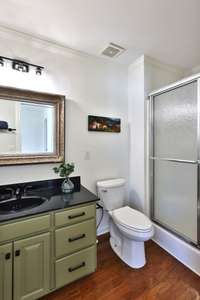 Chunky pulls on the drawers with knobs for the cabinet doors, black faucet, matching towel bar and light fixture.
