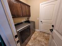 Large Laundry Room with Custom Cabinets for more storage.