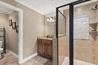 This bathroom has a tile shower with glass door and a private water closet.