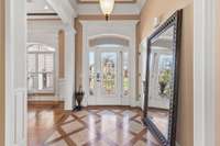 Inside the front entry hall has 12 ft ceiling and hardwood floors with inlaid stone.