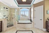 This luxurious primary bathroom will make you think you're in a spa. Custom tile flooring and barrel ceiling with crown molding are just right.