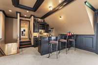 The wet bar includes granite counters, a sink, and built in wine rack.