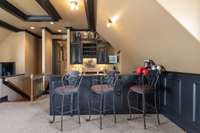 One corner of the recreation room is a dedicated wet bar with counter seating.
