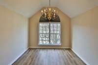 Formal dining room with beautiful window & chandelier. New LVP floors