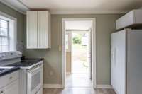 Kitchen with smooth top range, countertop microwave, side by side refrigerator, newer cabinets & laminate flooring, freshly painted. Kitchen could easily be redesigned using the current materials provided.