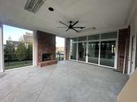 Stunning covered outdoor living oasis features a fireplace overlooking a private backyard and grilling porch with plenty of space for alfresco dining with ceiling heaters   Build by Legend Homes
*this home is under construction Photo taken 11/15/24