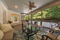 Relax on this screened-in private balcony looking over the patio and surrounded by lush greenery.