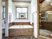 The Owner's bathroom also features an x-large shower w/ stone floors, a Soaking Tub with a stone backsplash, and Classic slate tile floor.