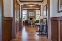 This entryway, with its wood paneling, trim, archways, and white oak flooring, is a lovely prelude to the interior rooms of this magnificent estate.