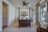 The inviting guest bedroom on the main level features a sitting area, a private bath, and a large walk-in closet with organizational shelving.
