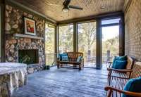 At the end of the great hall and just beyond the laundry room is the screened-in porch with a wood-burning fireplace surrounded by Riverstone. Board-and-batten ceilings. Beyond the porch is a large deck with spectacular views of the backyard.
