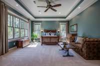 The primary bedroom brings the outdoors inside with four large windows overlooking the backyard and trees beyond, plus two windows overlooking the side yard. Cozy up to a warm fire in the stacked-stone gas fireplace during chilly weather.