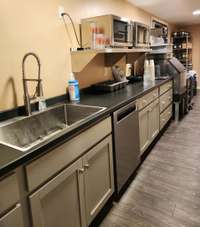 The Catering Kitchen has 50 ft.³ TurboAir cooler, 250-pound ice maker, a long countertop w/SS service sink, dishwasher, commercial coffee/tea brewer, two microwaves, swivel doors, service counter w/roll-up door, and catering door to exterior.