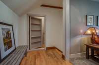Two bookcases at the top of the stairs serve as secret doors to large storage areas and the third-level loft/ studio/ workout area.