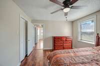 Master bedroom features fresh paint, luxury vinyl plank flooring and a ceiling fan.