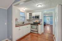 Spacious and updated kitchen features back splash, updated LVP flooring and stainless steel stove, built in microwave and eat in kitchen