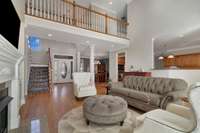 The living room is open to the kitchen, foyer, dining room and the steps are tucked away.