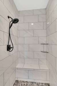 Tile shower with a bench .