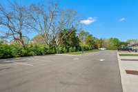 Looking towards the opposite side of the garage entrances; additional guest parking that backs up to a line of trees.