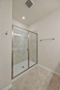 Large, walk-in shower with tile surround.