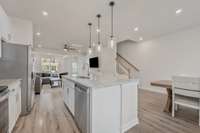 This view from near the kitchen pantry shows how open the main floor of this townhome is. Notice the dishwasher in the island.