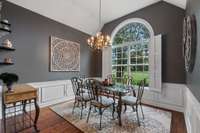 The formal dining room showcasing a large window that floods the space with natural light.