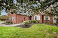 The exterior of this home exudes timeless charm with its all-brick façade, offering durability and elegance. Surrounded by mature trees that provide both shade and privacy, the property is complemented by a well-maintained sidewalk.