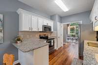 Overhead lighting illuminates the timeless kitchen, enhancing its classic design while providing a warm, inviting ambiance for everyday cooking and entertaining.