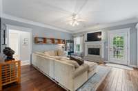 Living room presents 3/4 inch acacia wood flooring, gas fireplace & exterior door leading to the exterior deck.