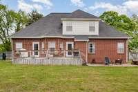 The back deck provides the perfect spot for outdoor entertaining or quiet relaxation, offering plenty of space for seating, dining, or enjoying the fresh air. Overlooking the large, well-maintained backyard.