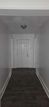 View from the beginning of the foyer leading from kitchen area to backdoor, and bedrooms #2 & #3.