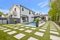 View of a portion of the easy to maintain and care for yard complete with turf and paver stones, automated irrigation and lighting. Plus a view of the private entrance to the guesthouse (stairs leading to door on 2nd floor)