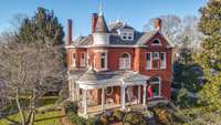 The home has an elegant turret room with curved glass and roof gable finials. There is a pulldown ladder that leads to a large attic for storage.