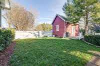 View of the back yard along the back property line towards the side fence.