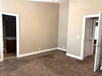 Main bedroom with vaulted ceilings and a built-in wall recess for furniture storage to enhance the overall flow of the room.