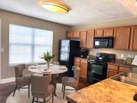 The kitchen features ample cabinetry, offering plenty of storage space for kitchen essentials and personal items. (Virtually Staged)
