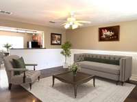 Living room is open to kitchen/dining area for extended natural lighting on the main level. (Virtually Staged)