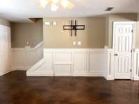 Large living room with wainscoting panels throughout.