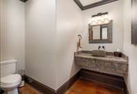 Lower level powder room features a handsome vanity and stone vessel sink