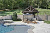 Outdoor kitchen boasts a built-in gas grill, a Green Egg grill and bar seating