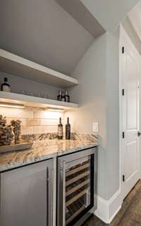 Conveniently located beverage/serving bar complete with a beverage refrigerator and ice maker