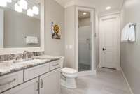 En-suite bathroom with extended vanity, tile flooring, tiled shower & linen closet