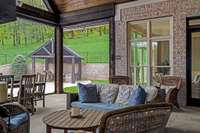 Flowing off the great room, this large covered porch features a floor-to-ceiling wood-burning fireplace with a gas starter, ceiling fan, retractable screens and built-in porch heater