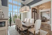 The formal dining room is enhanced by quality mill work, a wall of windows with gorgeous hill views, an artistic coffered ceiling, and gleaming hardwood floors