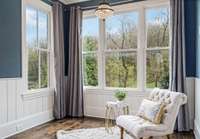 Sit back and relax in the charming sitting room that has amazing views of the hills and private wood backyard
