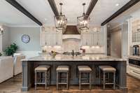 Huge center island features a farmhous sink and plenty of room for bar seating