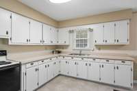 The kitchen has plenty of cabinets for storage.