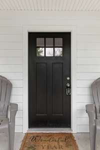 This beautiful black door offers a sleek dark contrast to the white house! Such stunning design choices!