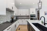 Cooking and storage are made even more enjoyable with rollout trays in the lower cabinets, a built-in trash bin drawer, and upgraded appliances.